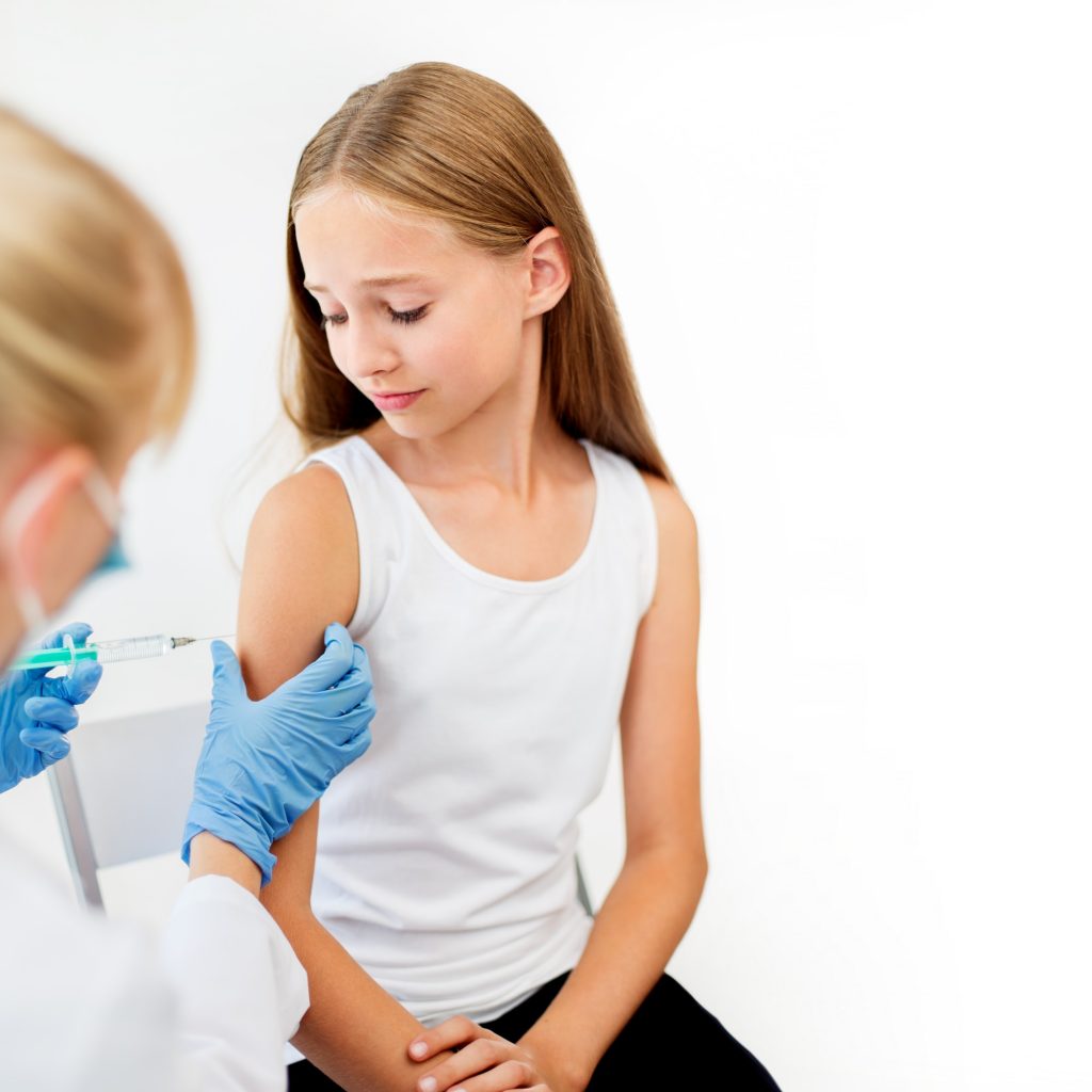 doctor with syringe making injection to girl