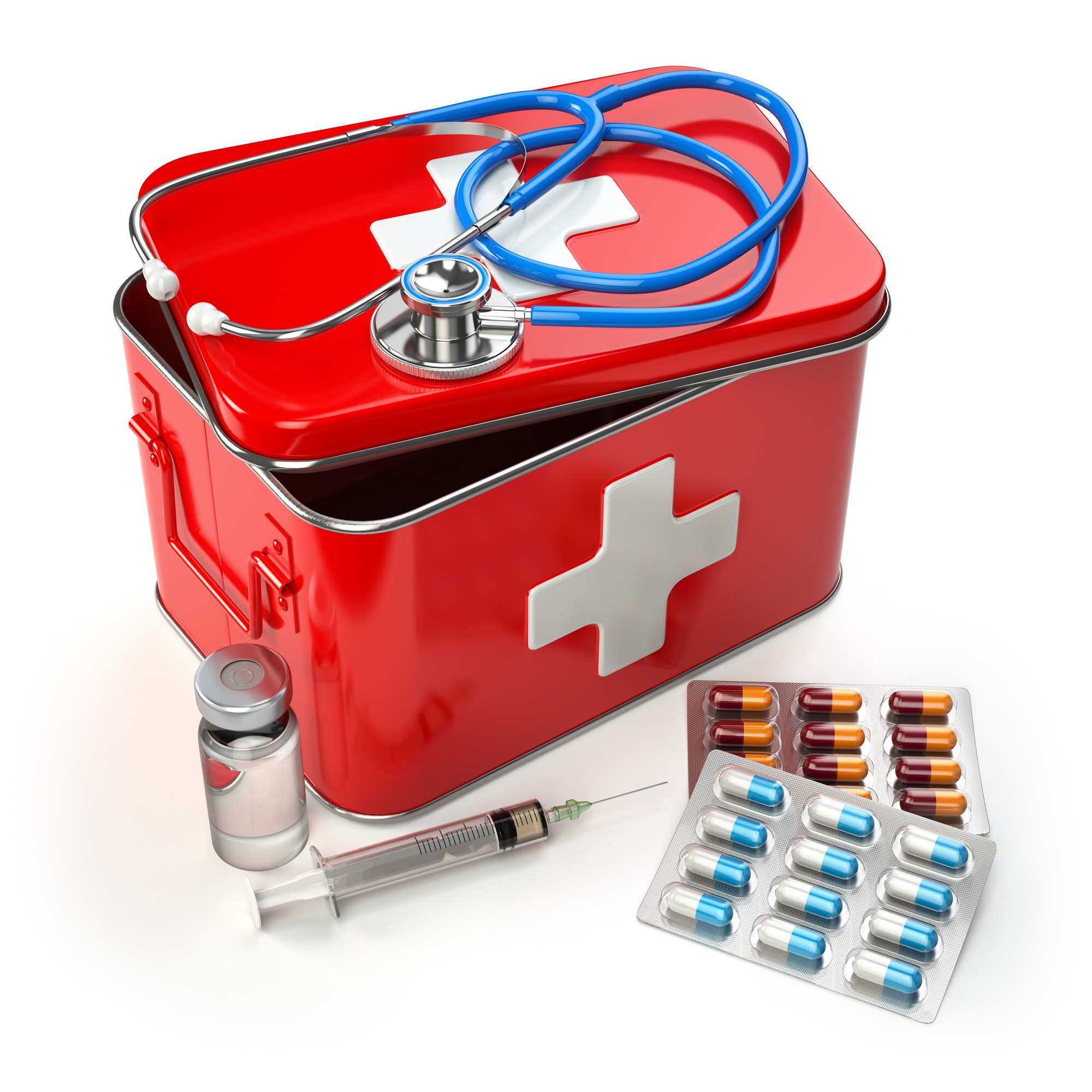 First aid kit with stethoscope, pills and syringe on the table.